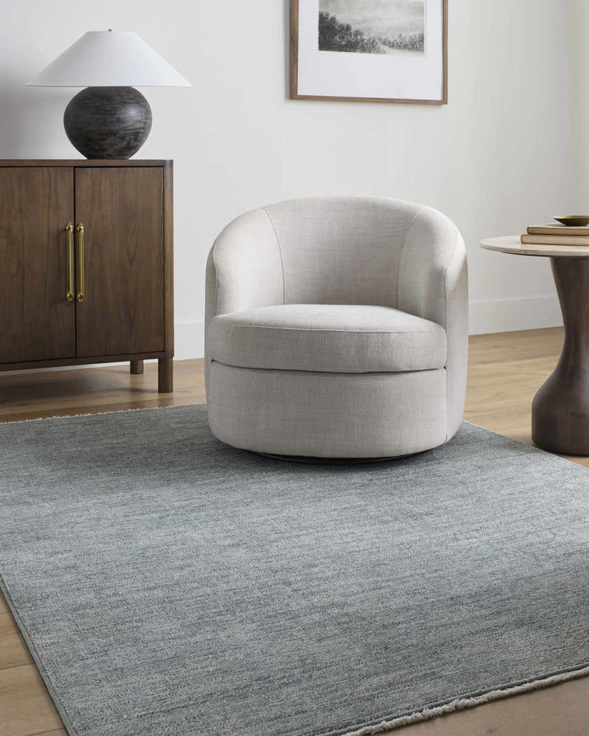 Living room scene with a gray Livabliss x Galey Alix Maria Elena II rug, cream swivel chair, and wood cabinet. Roomscene-Rectangle