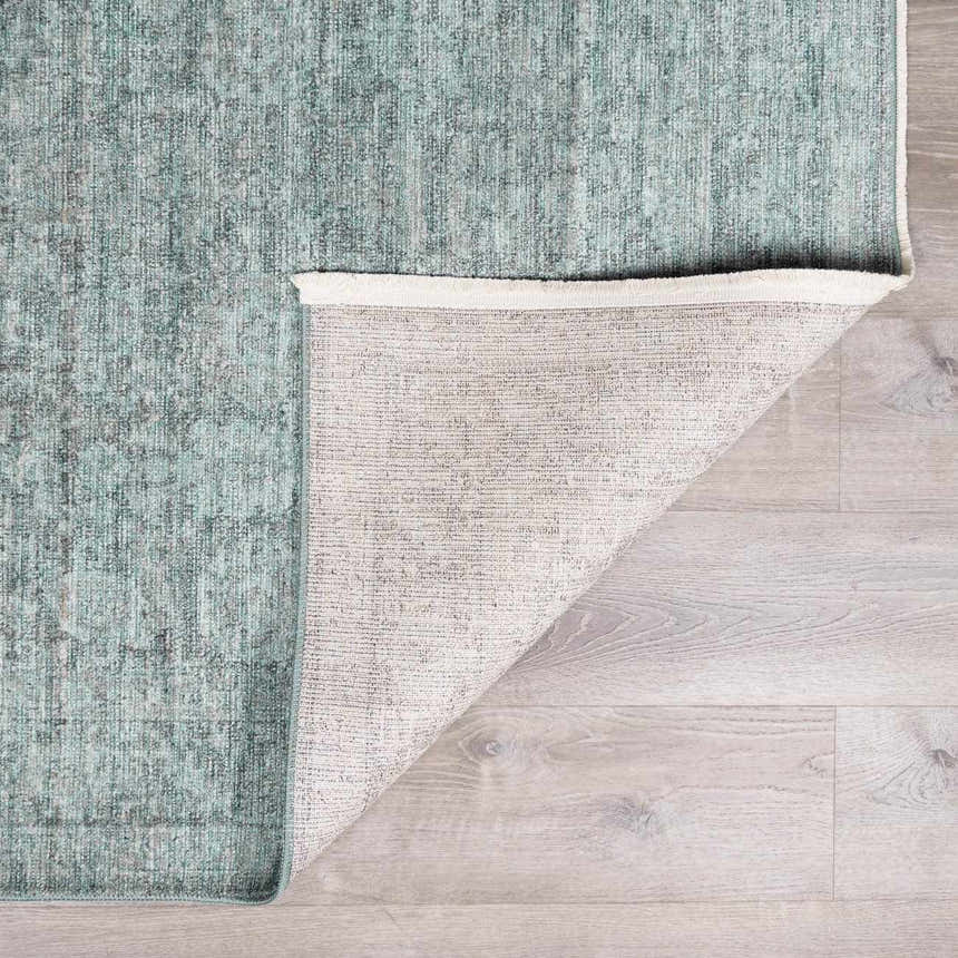 Close-up of Livabliss x Galey Alix Maria Elena II rug. Vintage medallion pattern in black, cream, and gray on a light wood floor. Fold