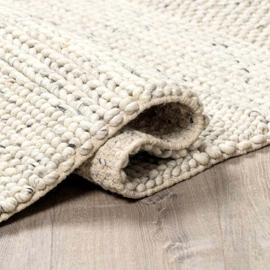 Close-up of the Salvo Luxury hand woven wool area rug in cream and black, showing its chunky texture. Fold