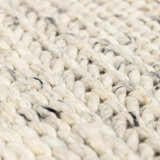 Close-up of the Salvo Luxury Rug, hand woven wool in cream and black. Shows the texture and natural fiber construction. Texture