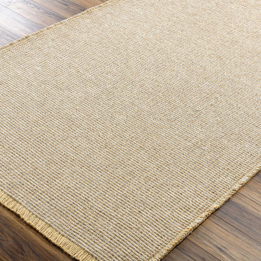 Close-up of the Kimi Machine Woven Becki Owens x LIVABLISS rug. Tan and gray jute texture with a farmhouse style. Corner