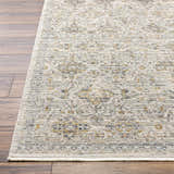 Close up of Ren Outdoor Becki Owens x LIVABLISS rug. Machine woven polyester rug in black, blue, brown, and taupe on wood floor. Front