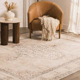 Living room scene with Lila Becki Owens x LIVABLISS rug, tan leather chair, side table, and neutral tones. Roomscene-Rectangle