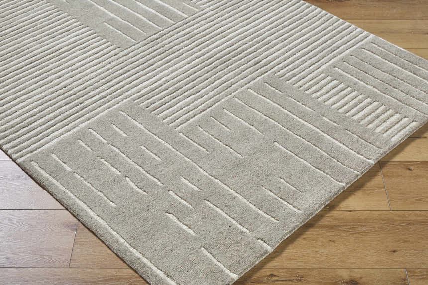 Close-up of the Akuji Area Rug showing its gray wool texture and contemporary white geometric line pattern. Corner