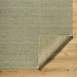Close-up of Verdel Sage rug showing sage, tan, and teal woven texture on wood floor. Farmhouse style area rug. Fold
