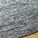 Close-up of the hand woven Kenyi Black Area Rug showing its black and white textured pattern. Texture