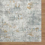 Close-up of the Fleur Textured Rug. Features a gray, white, and gold abstract pattern. Contemporary style rug. Corner