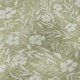 Close-up of the Dalyn Luxury Soft Essentials Aloe rug, showing a floral and leaf pattern in aloe green and white.