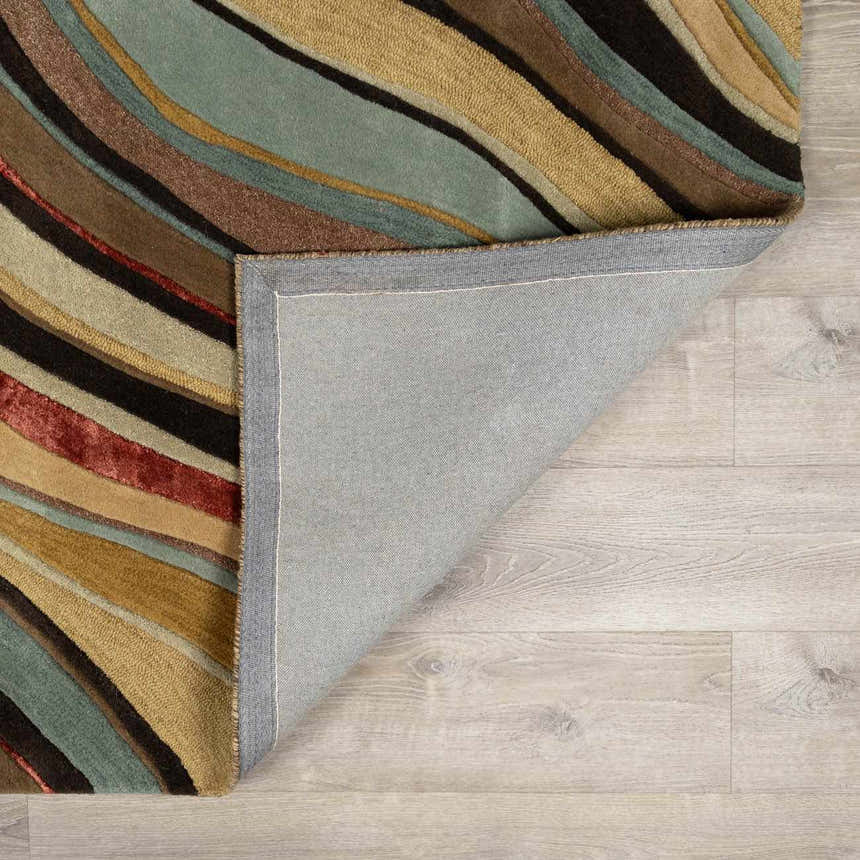 Close-up of the Seminole Area Rug showing the wool texture and wavy stripes in beige, brown, teal, and burgundy. Fold