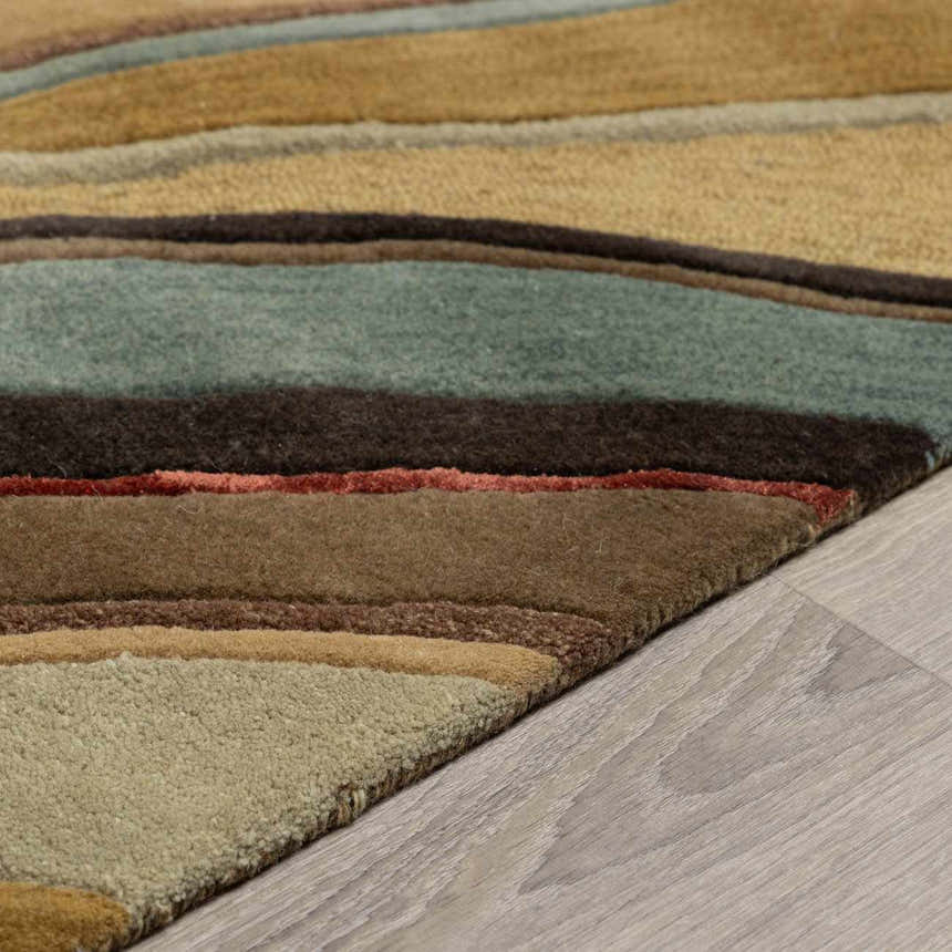 Close-up of the Seminole Area Rug showing beige, brown, teal, and burgundy stripes and wool texture. Pile