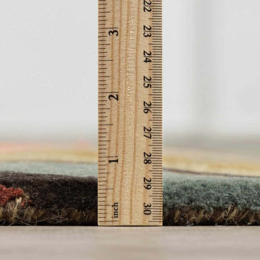 Close-up of Seminole Area Rug showing pile height with ruler. Colors: beige, black, burgundy, brown, mustard, olive, taupe, teal. Pile