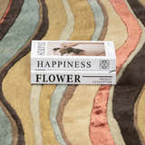 Close up of the Seminole Area Rug, a hand-tufted wool rug with beige, brown, teal, and coral wavy stripes. Styleshot