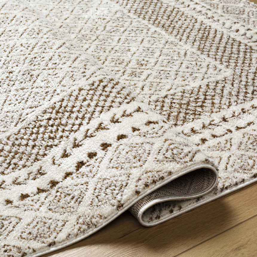 Close-up of the Julio Scandi Boho Area Rug in brown, beige, and ivory. Features a textured, geometric pattern. Fold