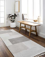 Entryway with Abia Gray Area Rug runner, wood bench, and plant. Neutral tones create a Scandinavian feel. Roomscene-Runner