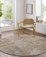Light-filled room with round Sava Rust rug, woven chair, wood floors, and white walls. A cozy, contemporary scene. Roomscene-Round
