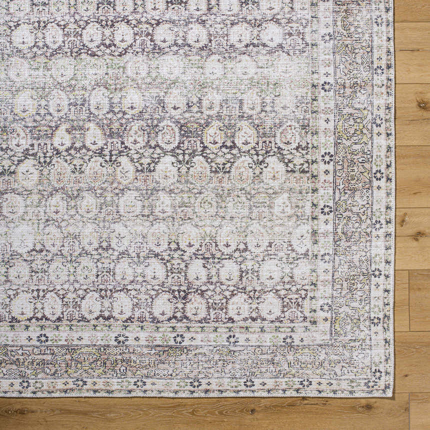 Close up of the Mabyn Area Rug showing its detailed, vintage-inspired pattern and soft polyester texture. Corner