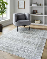 Living room scene with gray chair and neutral Mabyn Area Rug on wood floor. Roomscene-Rectangle