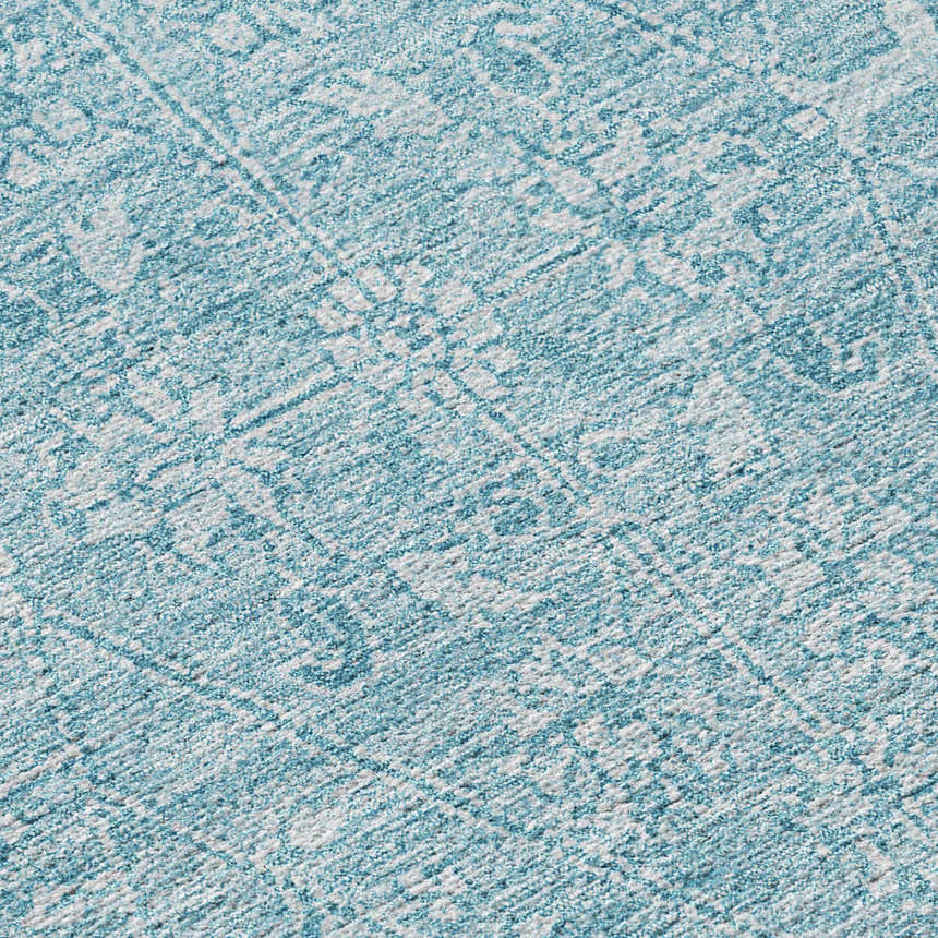 Close-up of the Dalyn Luxury Solace SL12 Sky Washable Area Rug. Features a sky blue and white farmhouse-style pattern.