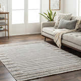Living room with a cream sofa and the Sulak Cream Area Rug, a striped rug with fringe detail. Roomscene-Rectangle