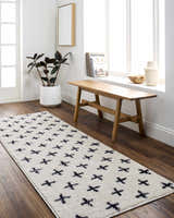 Entryway with Bede Washable Area Rug in beige with charcoal geometric cross pattern. Farmhouse style with wood bench and plant. Roomscene-Runner