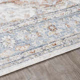 Close-up of the Emke Flat Pile Washable Rug. Features a traditional pattern in bone, beige, blue, and brown tones. Pile