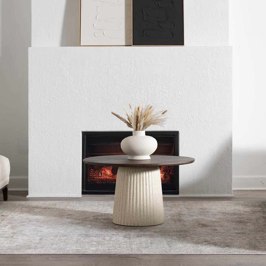 Living room scene with fireplace and Gael Boutique Washable Rug in light blue and tan under a round table with vase. Roomscene-Rectangle