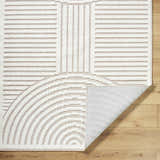 Close up of the Deron Ivory 3D Rainbow Washable Rug. Off white rug features a geometric rainbow design and a light gray backing. Fold