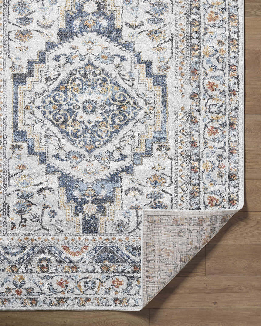 Close-up of the Paula Off White Area Rug showing its traditional charcoal, brown, and mustard floral pattern. Fold