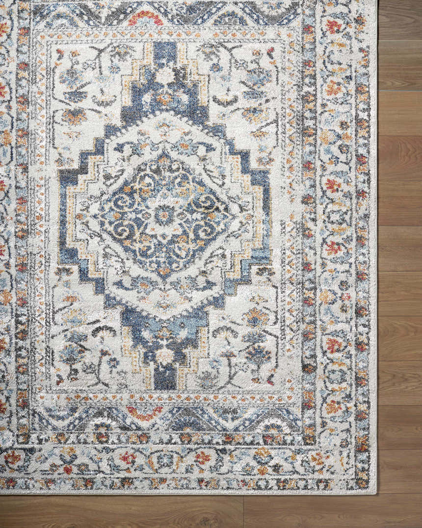 Close-up of the Paula Off White Area Rug showing its traditional charcoal, rust, and blue floral pattern. Corner