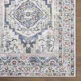 Close up of the Paula Off White Area Rug showing its traditional charcoal, light brown, and mustard pattern. Corner