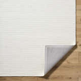 Close up of the hand woven Alyra Silver Slate Wool Rug showing its light silver color and texture. Fold