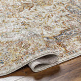 Close-up of the Aman Beige Area Rug showing its traditional pattern, brick red, mustard, and blue colors, and soft texture. Fold