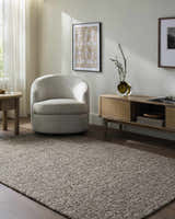 Living room scene with a Sevan Taupe Wool Area Rug, gray armchair, and wood media cabinet. Neutral, modern farmhouse style. Roomscene-Rectangle