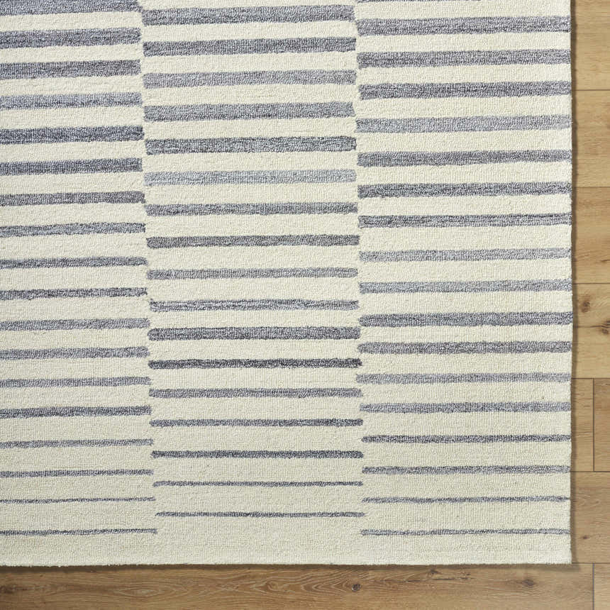 Close-up of the Gawel Gray Area Rug showing the charcoal striped, hand-tufted design and wool texture. Corner