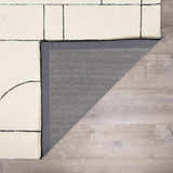Close-up of the Fusao Rose Cream Area Rug showing its geometric design, cream color, and wool texture. Fold