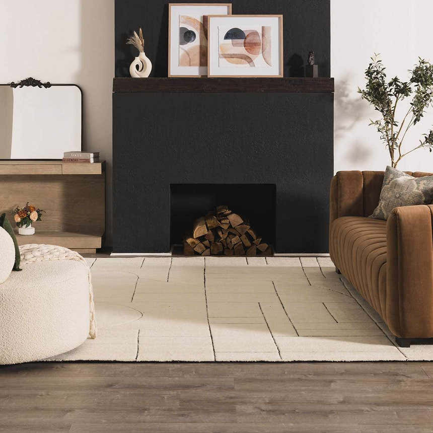 Living room scene with a Fusao Rose Cream Area Rug, brown sofa, fireplace, and modern decor. Roomscene-Rectangle
