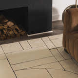Living room scene with a beige Fusao Rose Cream Area Rug, brown sofa, and black fireplace with wood. Roomscene-Rectangle