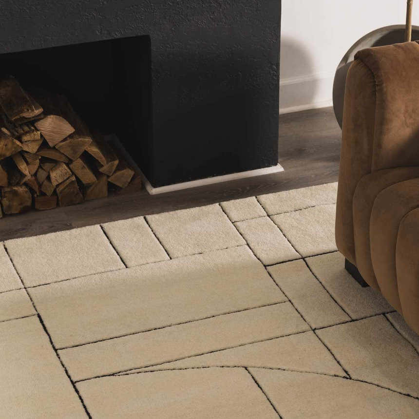 Living room scene with a beige Fusao Rose Cream Area Rug, brown sofa, and black fireplace with wood. Roomscene-Rectangle