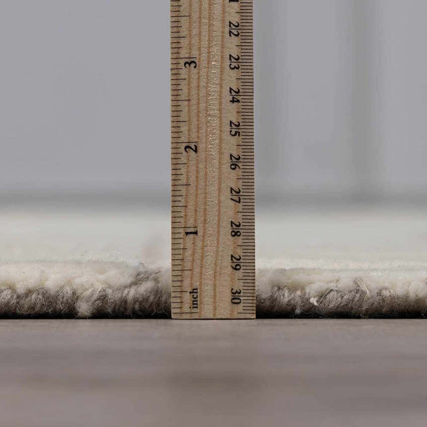 Close-up of the pile height of the Fusao Off White Area Rug, a hand-tufted wool rug. Pile