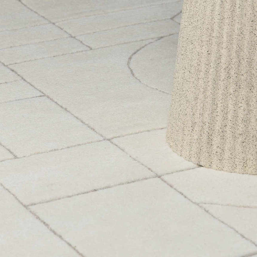 Close-up of the Fusao Off White Area Rug, a hand-tufted wool rug with a geometric pattern in light silver and off white. Styleshot