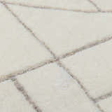 Close-up of the hand-tufted Fusao Off White Area Rug, showing its wool texture and light silver geometric pattern. Texture