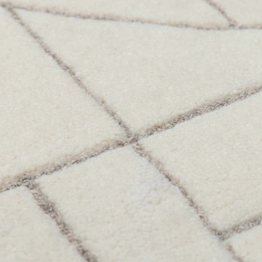 Close-up of the hand-tufted Fusao Off White Area Rug, showing its wool texture and light silver geometric pattern. Texture