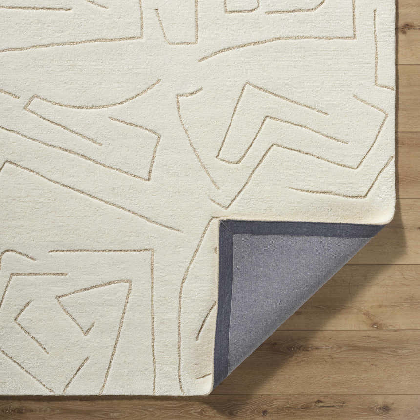 Close-up of the hand-tufted Mony Beige Area Rug. Features a geometric beige pattern on a soft, textured, cream-colored wool. Fold