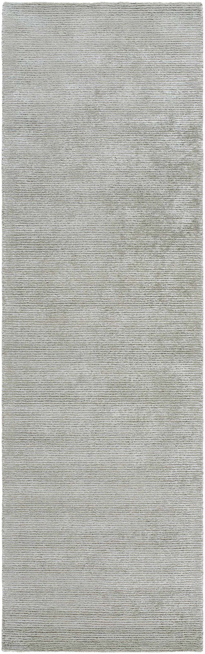 Close-up of the Makya Area Rug. Silver gray rug with a subtle horizontal striped texture. Hand-tufted viscose. Design-Runner-310
