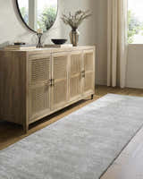 Entryway with a silver Makya Area Rug, light wood floors, and a cane cabinet. Roomscene-Runner