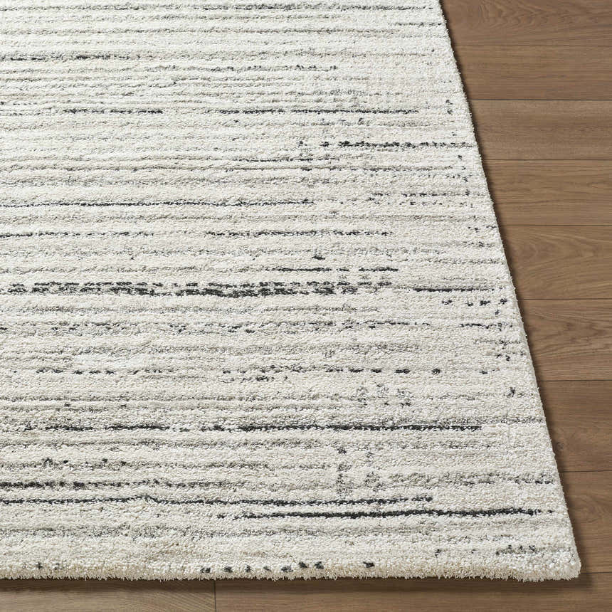 Close-up of the Salus Luxe Rug. Beige and white rug with a subtle black horizontal line pattern. Contemporary style. Front