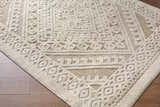 Close-up of the Hibah Bone Area Rug. Beige and bone rug with a contemporary geometric pattern and textured weave. Corner