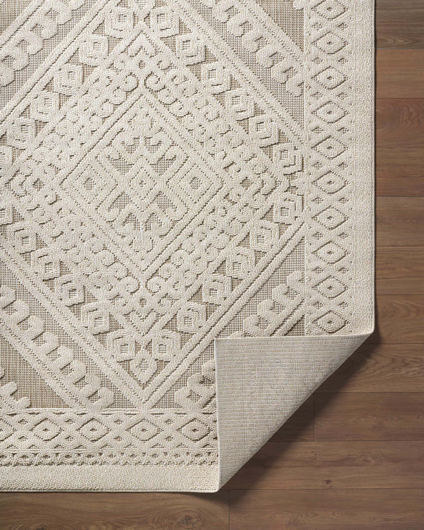 Close-up of the Hibah Bone Area Rug showing its beige geometric pattern and woven texture on a wood floor. Fold