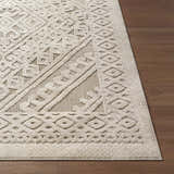 Close-up of the Hibah Bone Area Rug showing its geometric pattern and textured weave on a wood floor. Front
