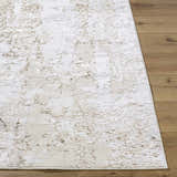 Close-up of the Junko Area Rug. Beige, cream, and tan abstract design with a soft, textured feel on wood flooring. Front